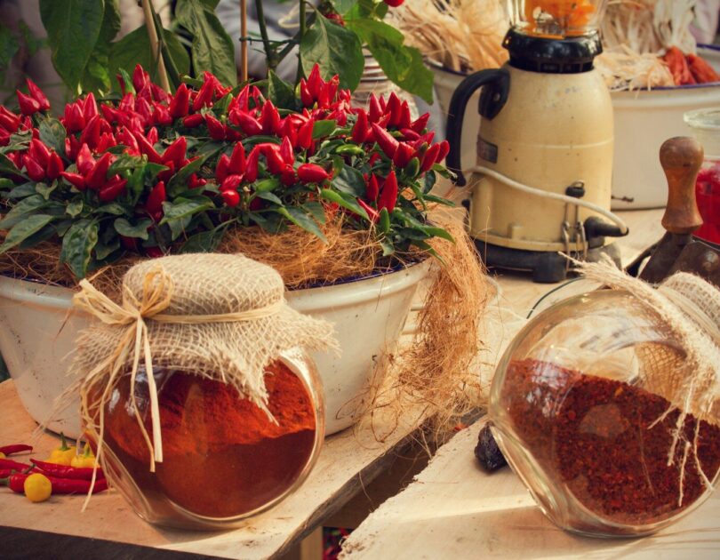 a table topped with pots filled with red flowers