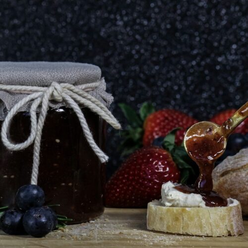 a glass jar with a straw and a couple of strawberries
