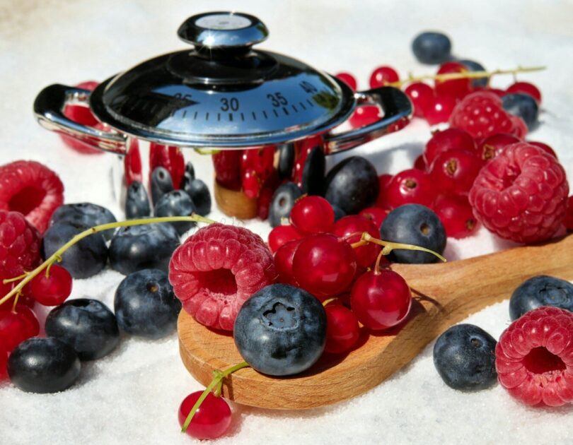 black and red berries on brown wooden spoon