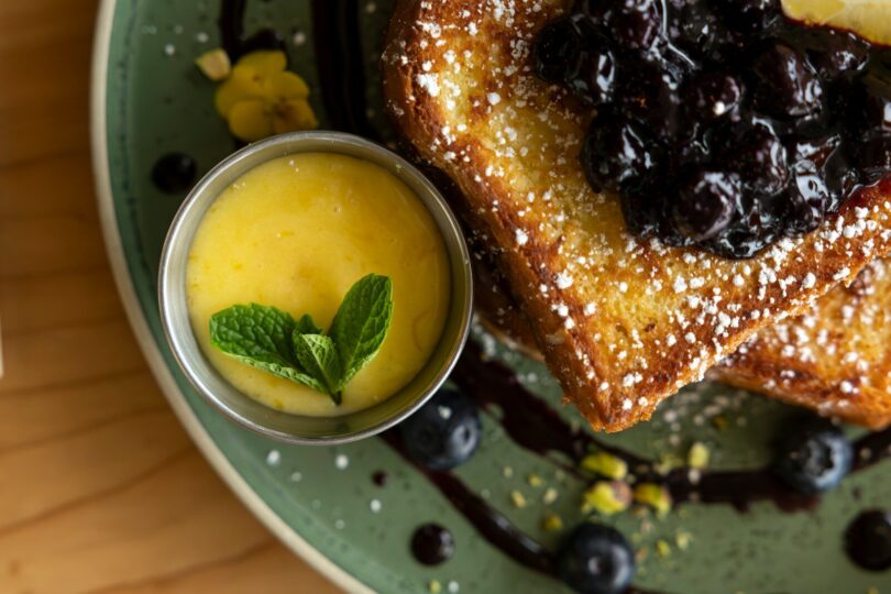 A plate with a piece of bread and blueberries on it